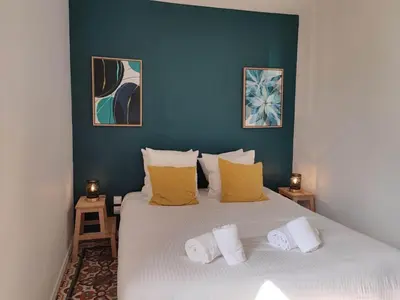 a bedroom with a large white bed with yellow pillows at La Terrasse du Temps Jadis in Carcassonne