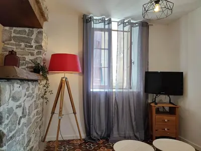 a room with a window with a television and a tripod at Studio du Charme Médiéval ConciergerieDameCarcas in Carcassonne