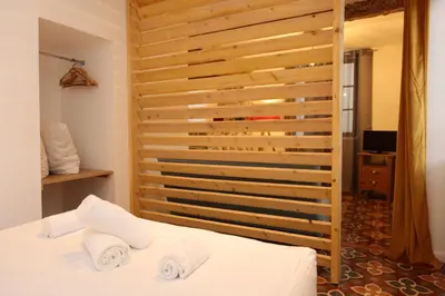 a bedroom with a bed with two towels on it at Studio du Charme Médiéval ConciergerieDameCarcas in Carcassonne