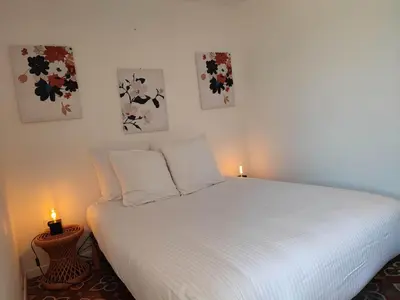 a bedroom with a white bed with two candles on it at Studio du Charme Médiéval ConciergerieDameCarcas in Carcassonne