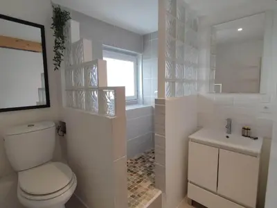 a white bathroom with a toilet and a sink at Studio du Charme Médiéval ConciergerieDameCarcas in Carcassonne
