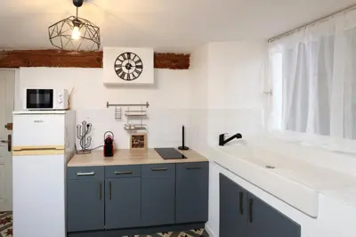 a kitchen with blue cabinets and a white sink at Studio du Charme Médiéval ConciergerieDameCarcas in Carcassonne