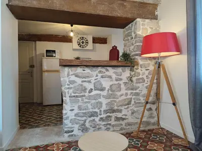 a red lamp sitting next to a stone wall at Studio du Charme Médiéval ConciergerieDameCarcas in Carcassonne