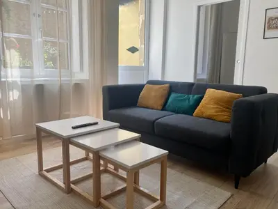 a living room with a blue couch and a table at Le Jardin Secret ConciergerieDameCarcas in Carcassonne