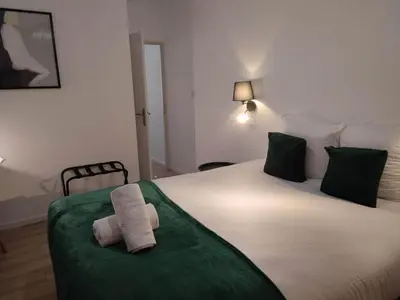 a bedroom with a large bed with two towels on it at Le Jardin Secret ConciergerieDameCarcas in Carcassonne