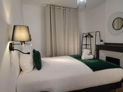 a bedroom with a bed with a lamp on it at Le Jardin Secret ConciergerieDameCarcas in Carcassonne