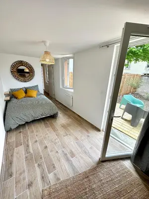 a living room with a bed and a mirror at Evasion dépaysante Canal du Midi* Jardin &Terrasse in Castelnaudary