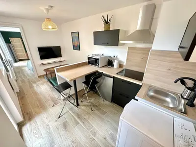 a small kitchen with a desk and a sink at Evasion dépaysante Canal du Midi* Jardin &Terrasse in Castelnaudary