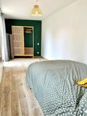 a bedroom with a bed and a green wall at Evasion dépaysante Canal du Midi* Jardin &Terrasse in Castelnaudary