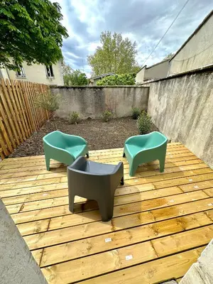 a patio with two chairs and a fountain on a wooden deck at Evasion dépaysante Canal du Midi* Jardin &Terrasse in Castelnaudary