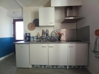 a kitchen with white cabinets and a sink at Charmant T2 indépendant in Belcaire