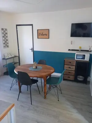 a dining room with a table and chairs at Charmant T2 indépendant in Belcaire